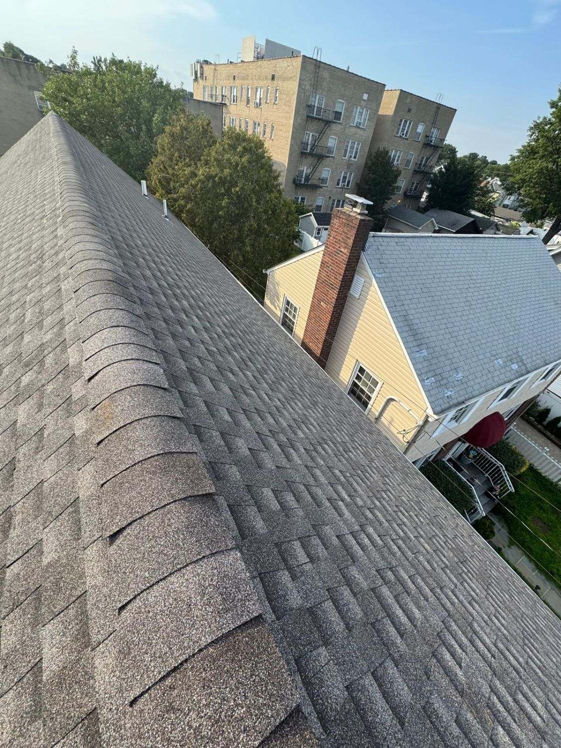 Close view of ridge cap shingles along the peak of a brown shingle roof