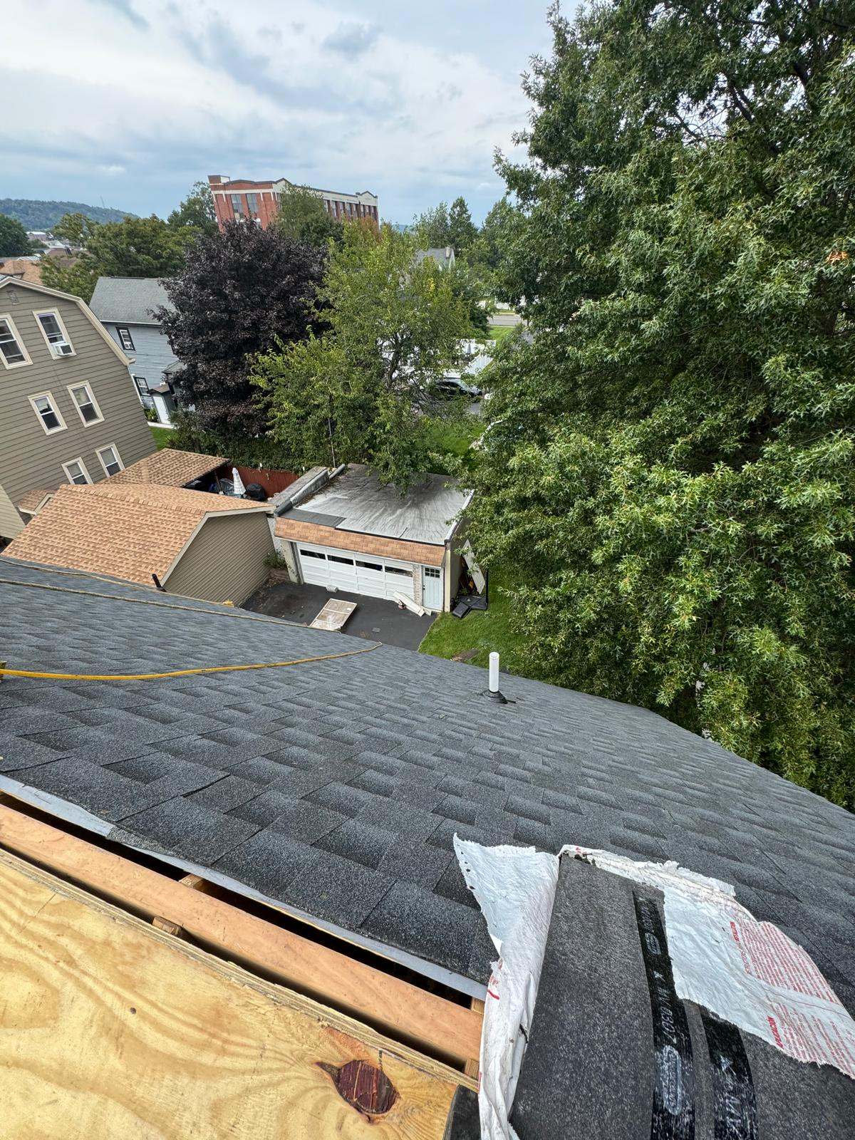 Dark architectural shingles around a white plumbing vent pipe